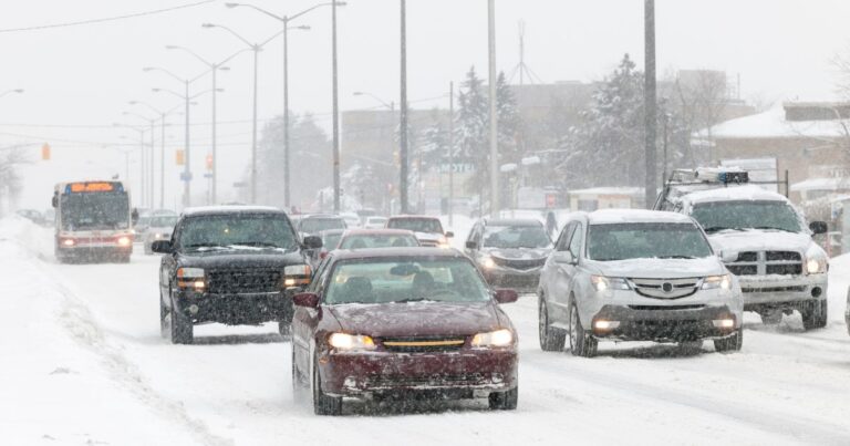 Cars driving in winter weather conditions with snow on the ground. 